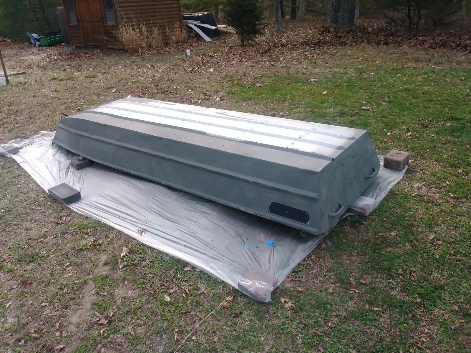 Hull flipped upside down on a tarp with primer coat applied
